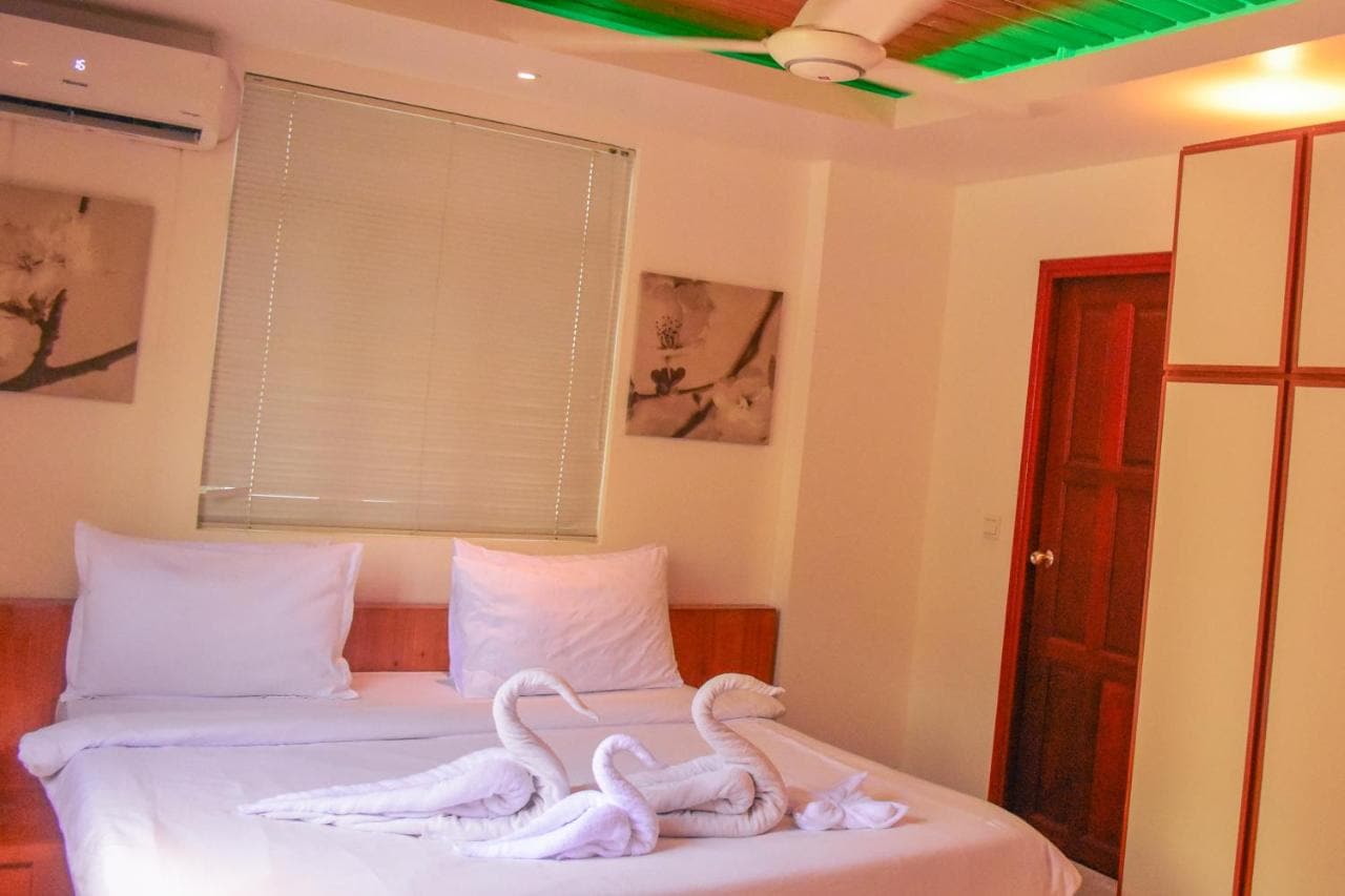 Standard Double room with a double bed, towels folded into swans and a window with blinds
